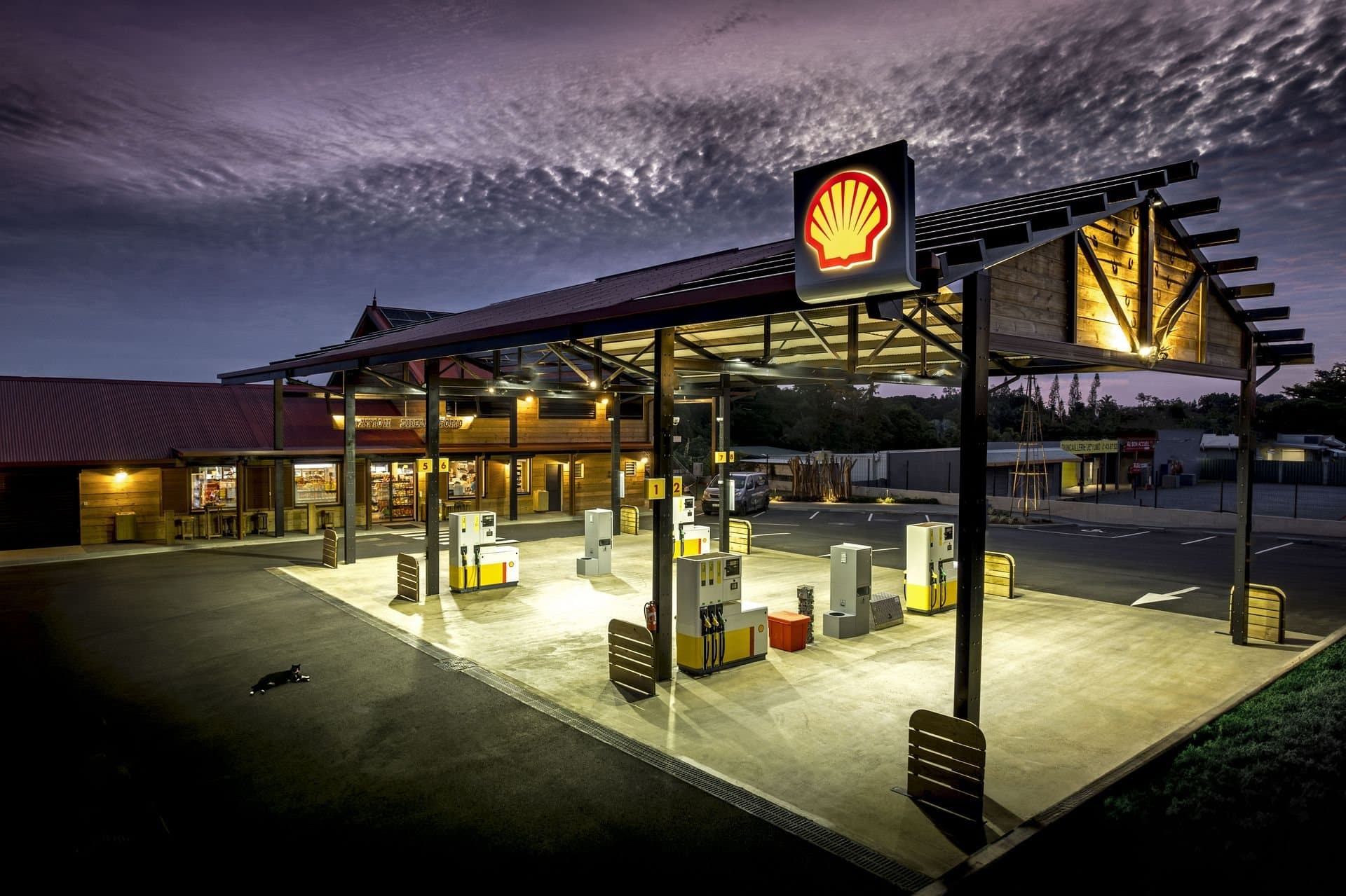 Station Shell de Tomo au crépuscule, charpente de bois et toiture rouge éclairées
