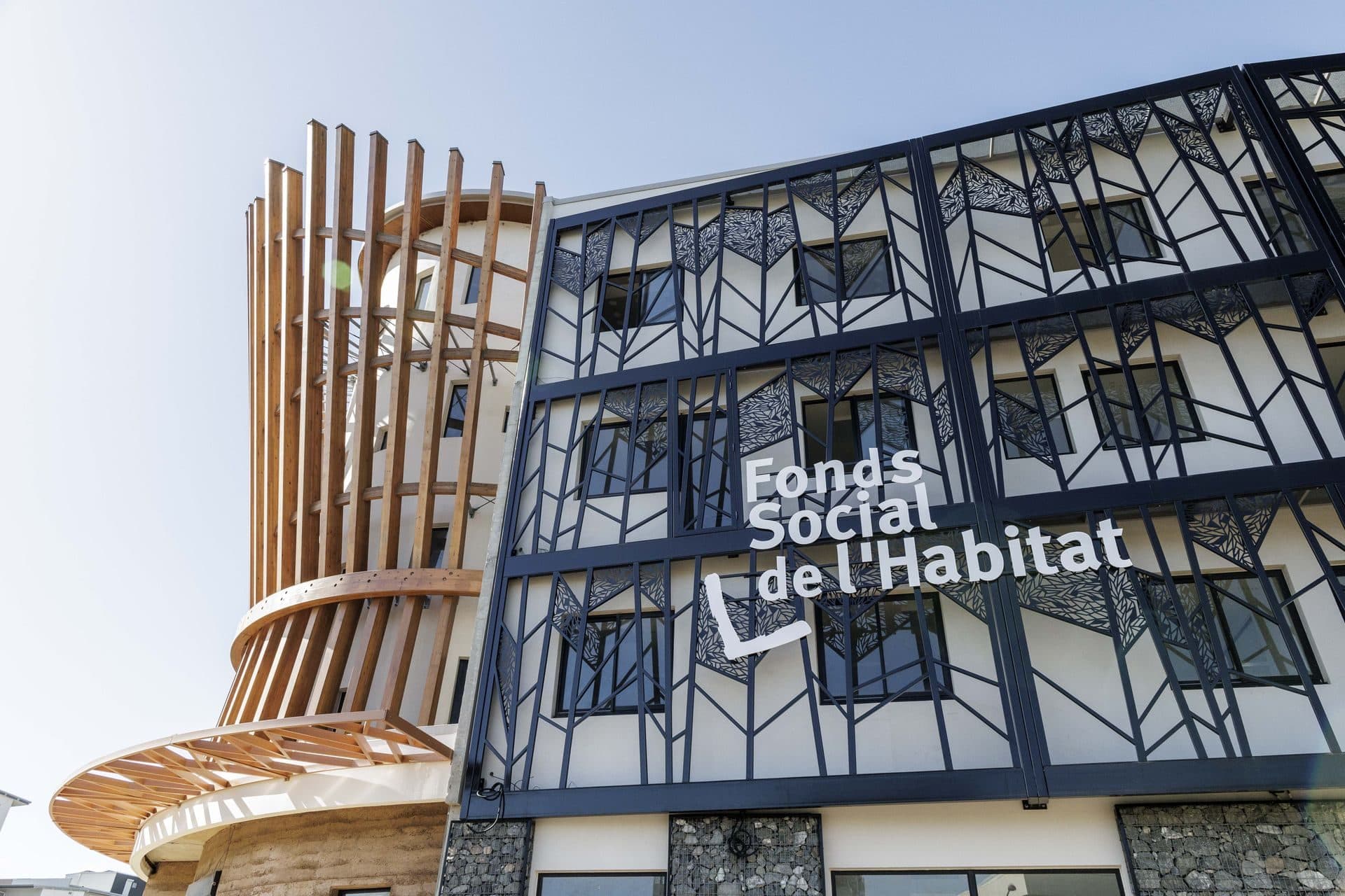 Façade du siège du FSH en contre-plongée, résille de bois et logo de l’institution