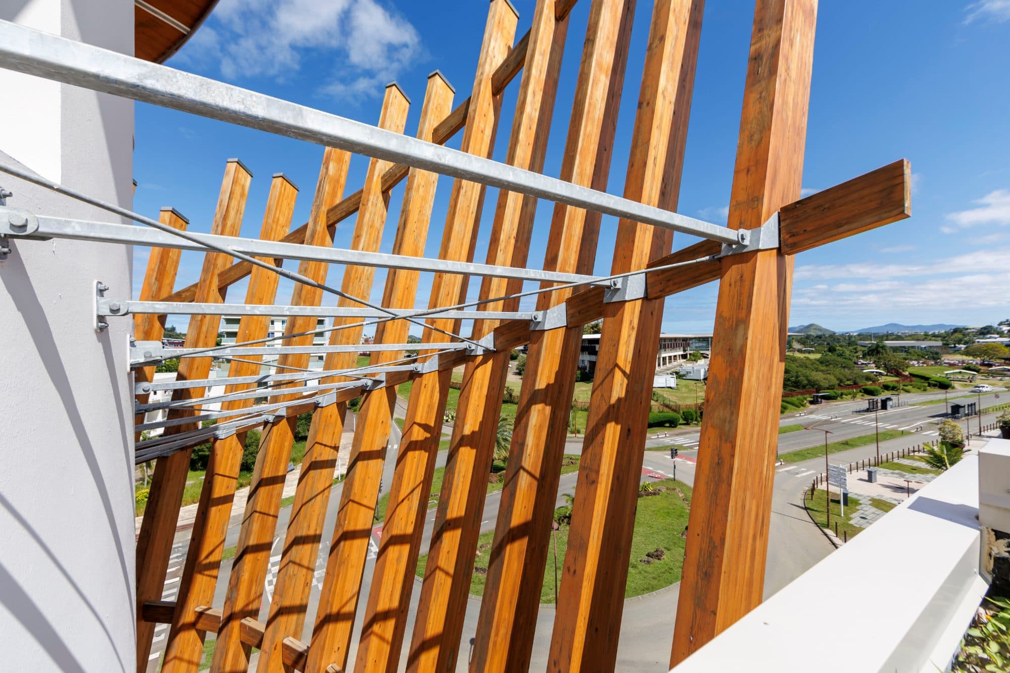 Résille de bois déployée en éventail au-dessus d’une terrasse